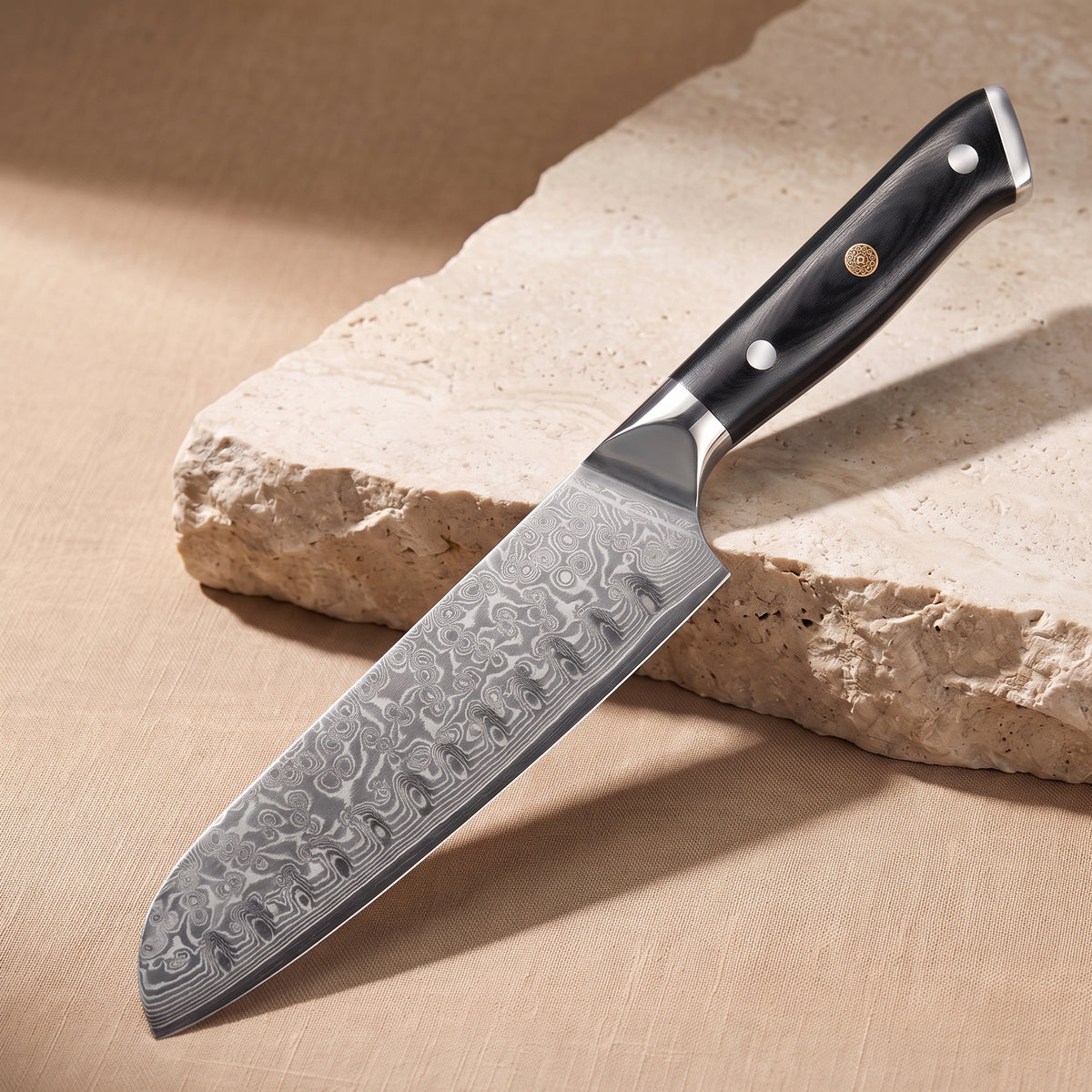 Santoku Knife 18 cm, Japanese Damascus steel, Galaxy Orion, black G10 handle with gold pin, on natural stone
