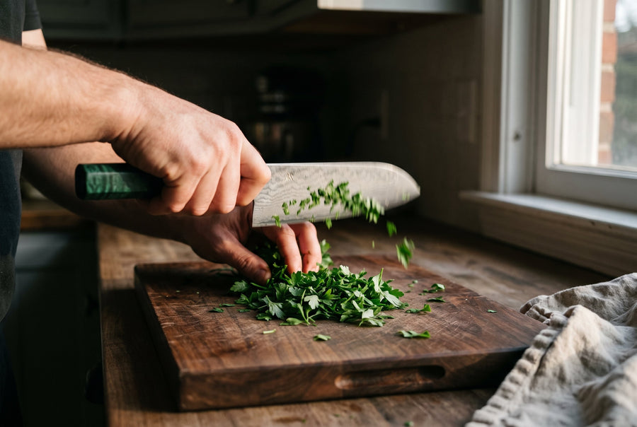 Chopping fresh parsley with a green-handled Damascus knife